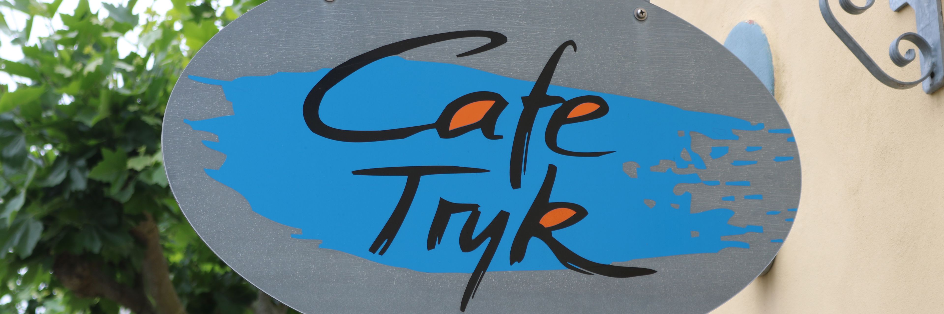 Skilt med navnetræk over Cafe Tryks indgang