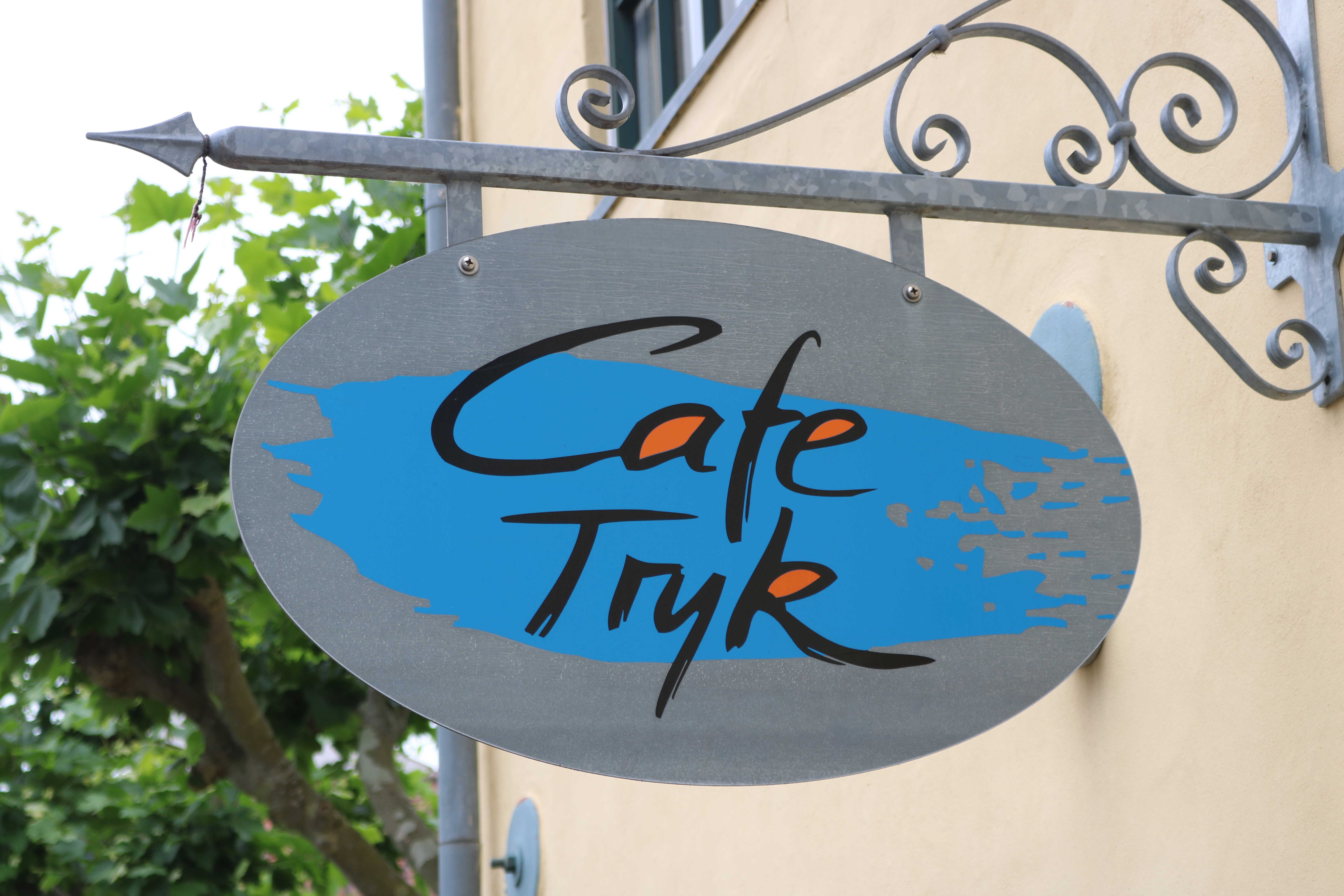 Skilt med navnetræk over Cafe Tryks indgang